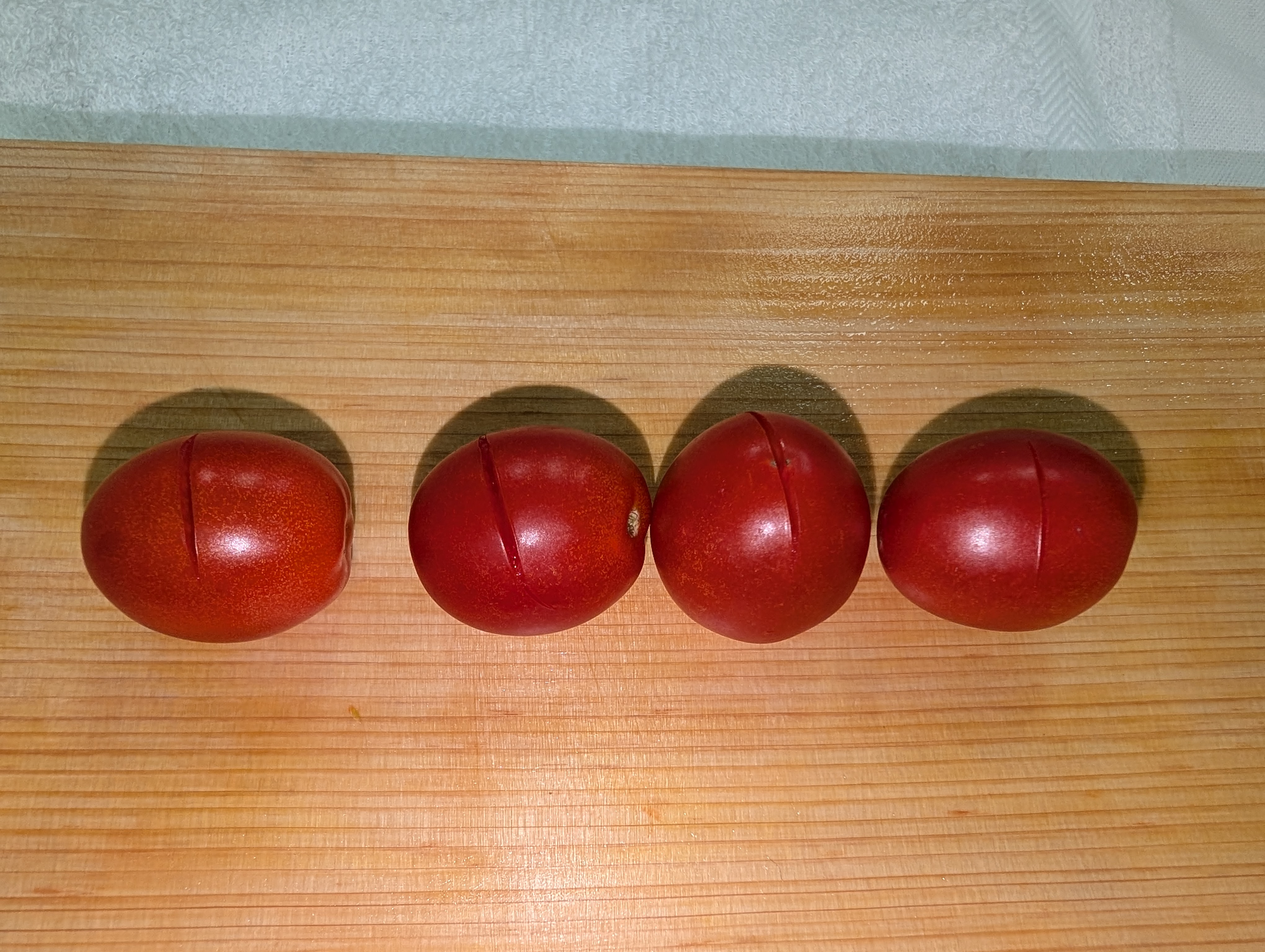 Four tomatoes showing different knife sharpness conditions